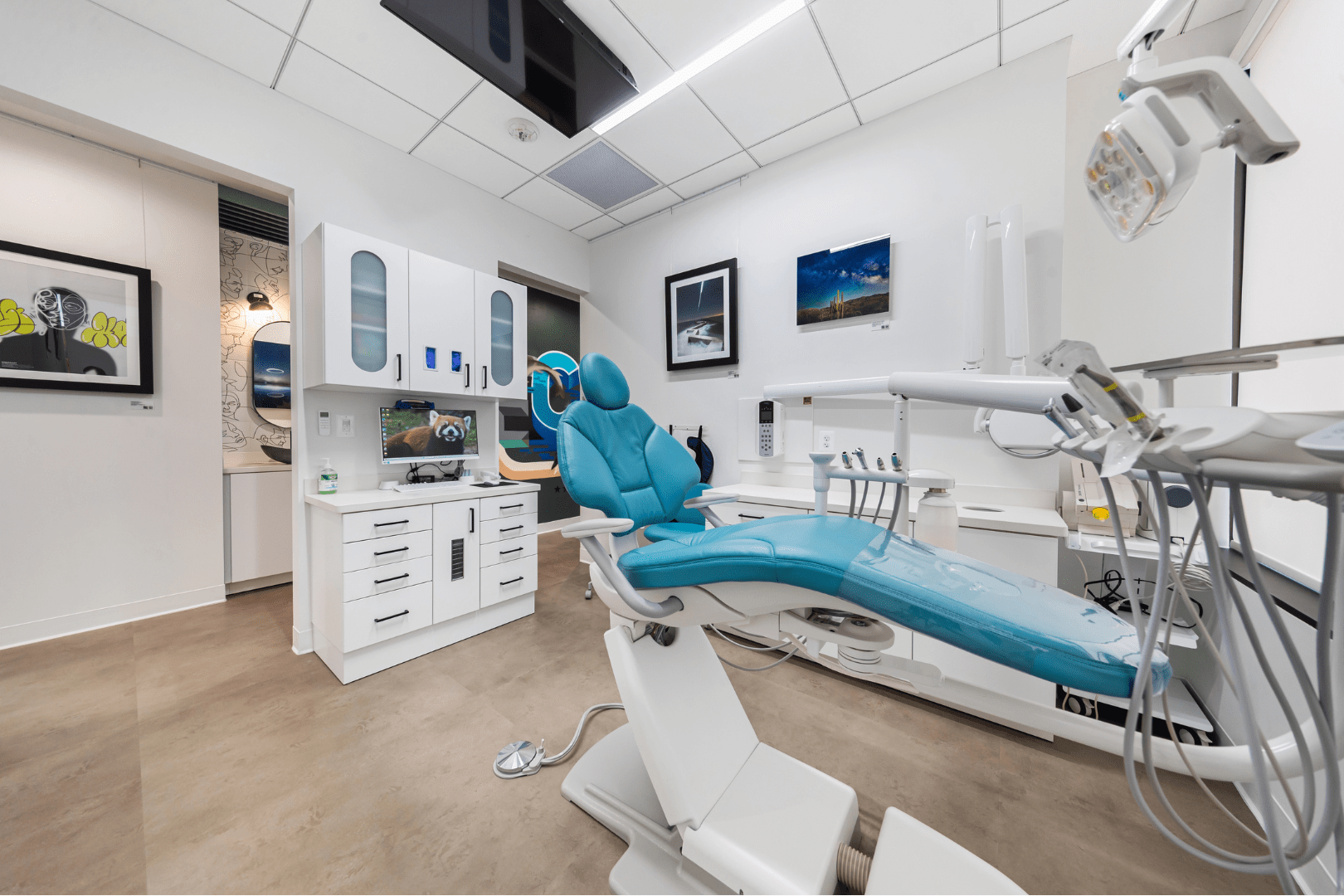 Techne Dental operatory with blue dental chair and rotating art